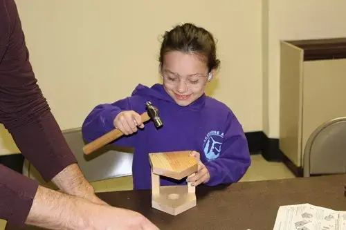 girl building a birdhouse